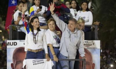 La líder opositora venezolana, María Corina Machado (i), y el candidato a la presidencia de Venezuela, Edmundo González Urrutia (d), saludan a simpatizantes antes del cierre de campaña de González Urrutia, este jueves, en Caracas (Venezuela). EFE/ Ronald Peña R.