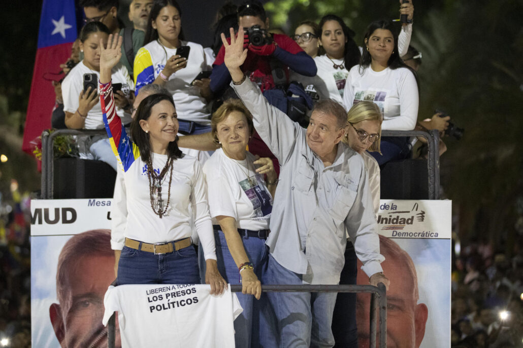 La líder opositora venezolana, María Corina Machado (i), y el candidato a la presidencia de Venezuela, Edmundo González Urrutia (d), saludan a simpatizantes antes del cierre de campaña de González Urrutia, este jueves, en Caracas (Venezuela). EFE/ Ronald Peña R.